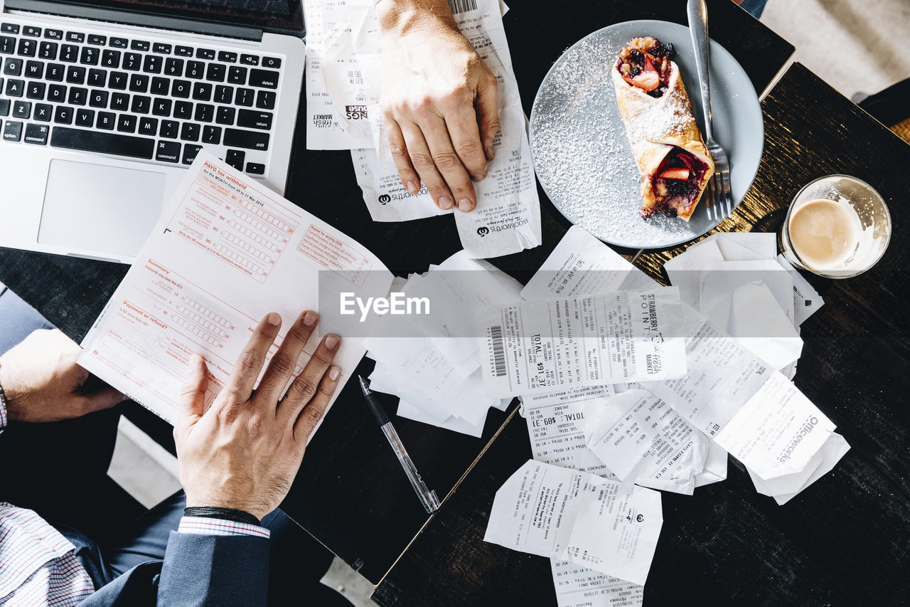 HIGH ANGLE VIEW OF PEOPLE ON TABLE AT HOME