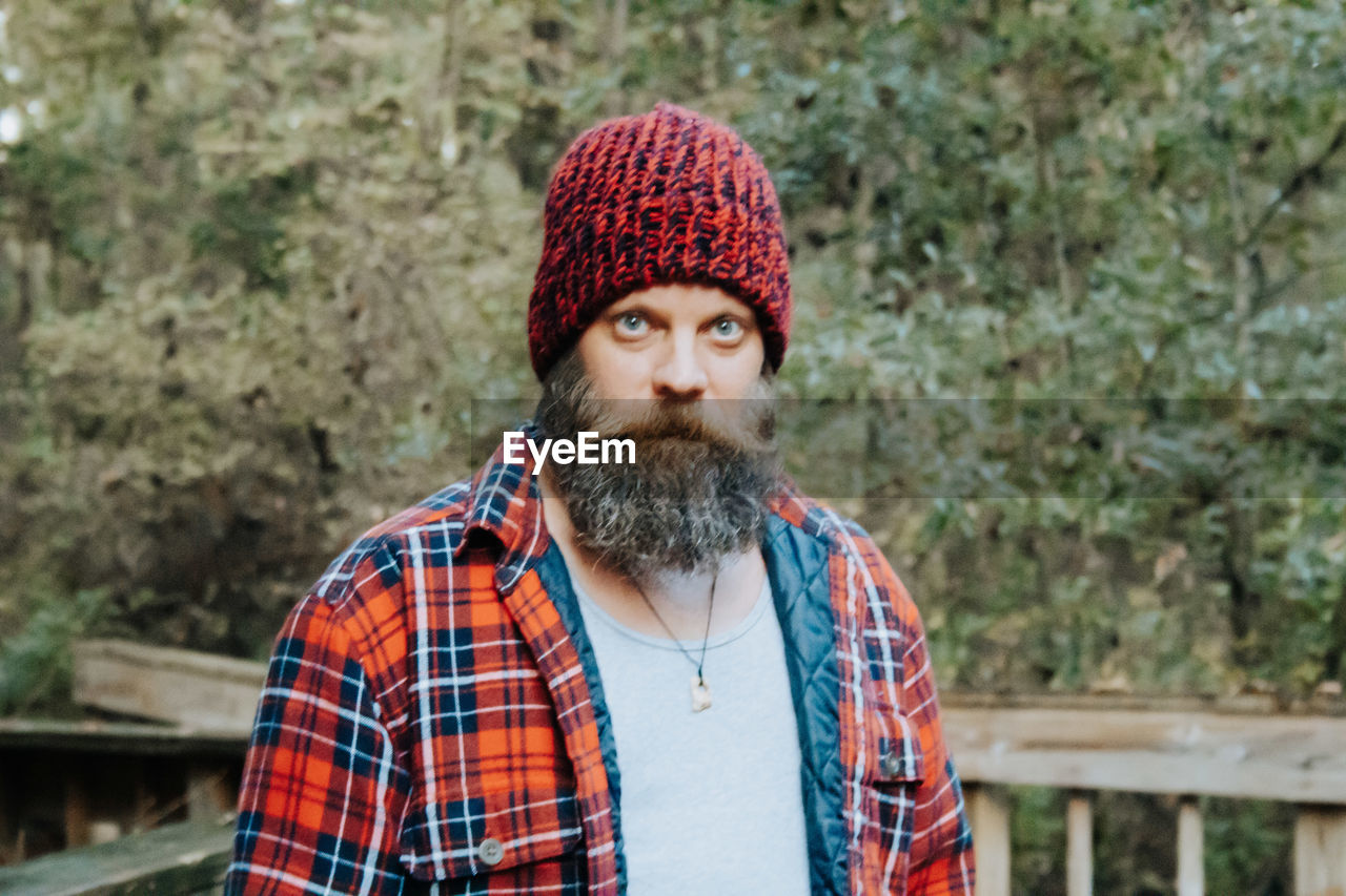 Handsome man with beard in plaid wearing hat.