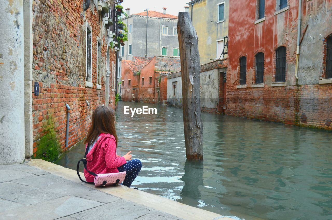 Woman sitting in canal