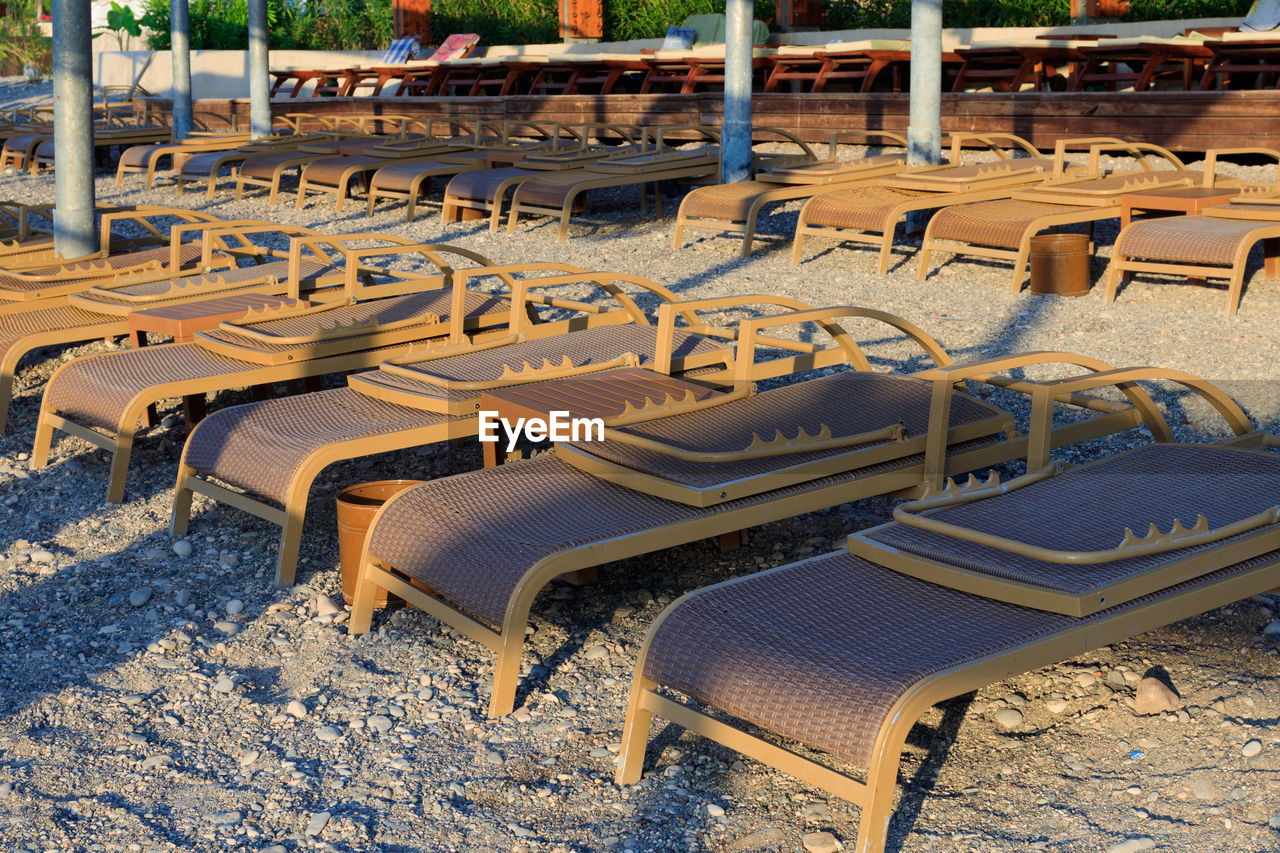 HIGH ANGLE VIEW OF EMPTY CHAIRS ON SNOW COVERED LAND