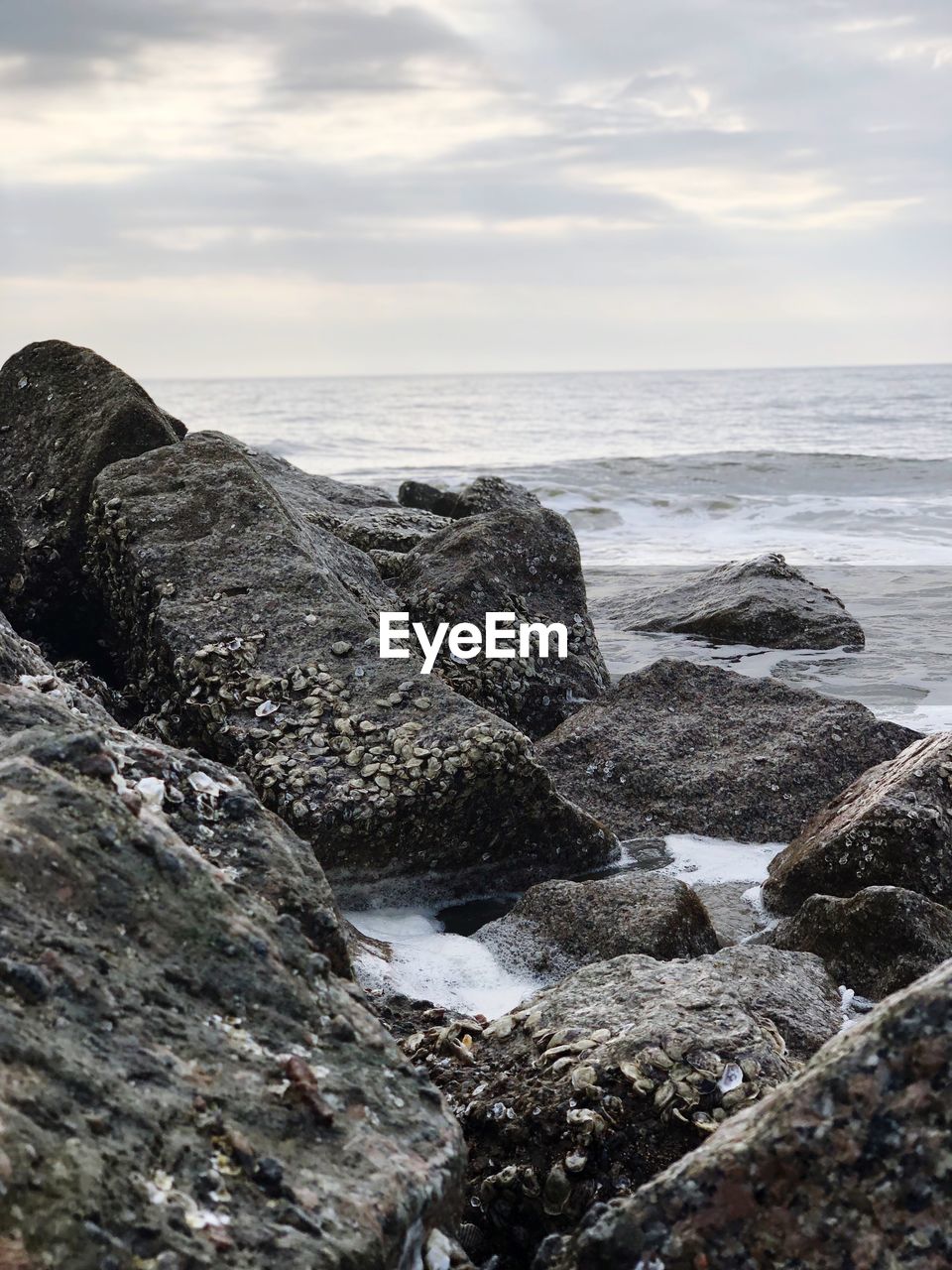 Rocks on beach against sky