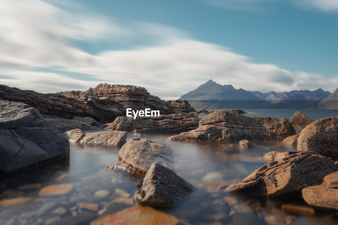 Scenic view of sea and mountains against sky