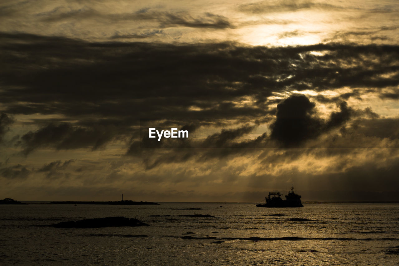 Silhouette boat sailing on sea against sky during sunset