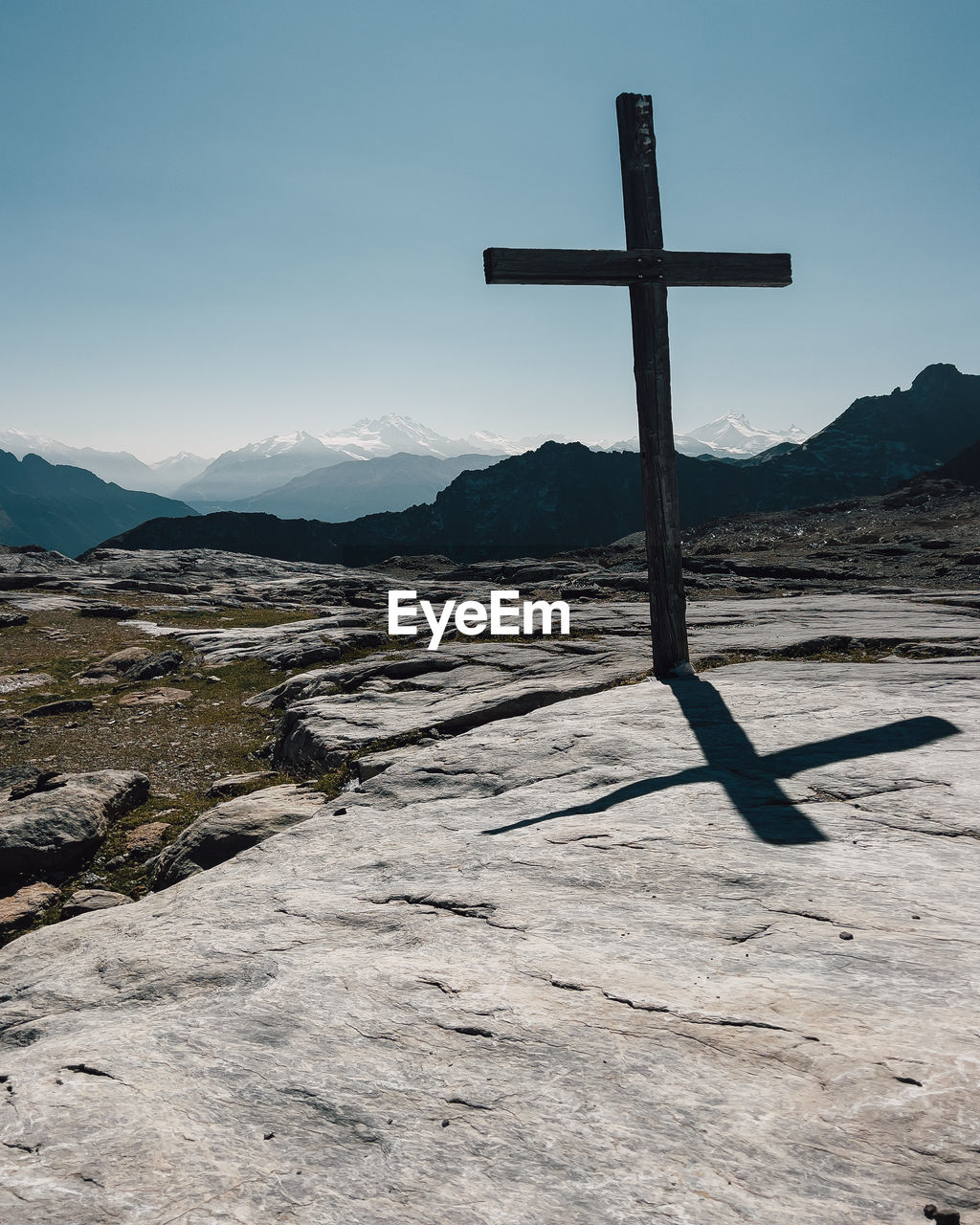 religion, belief, cross, spirituality, mountain, landscape, cross shape, nature, environment, sky, catholicism, scenics - nature, tranquility, beauty in nature, crucifix, symbol, no people, idyllic, tranquil scene, mountain range, land, place of worship, sunlight, outdoors, clear sky, snow, sea, non-urban scene, day, travel, blue, sunny, travel destinations, holiday, winter, cold temperature