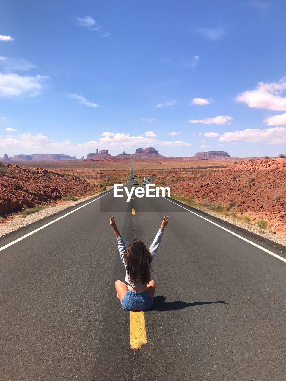 Rear view of woman on road against sky