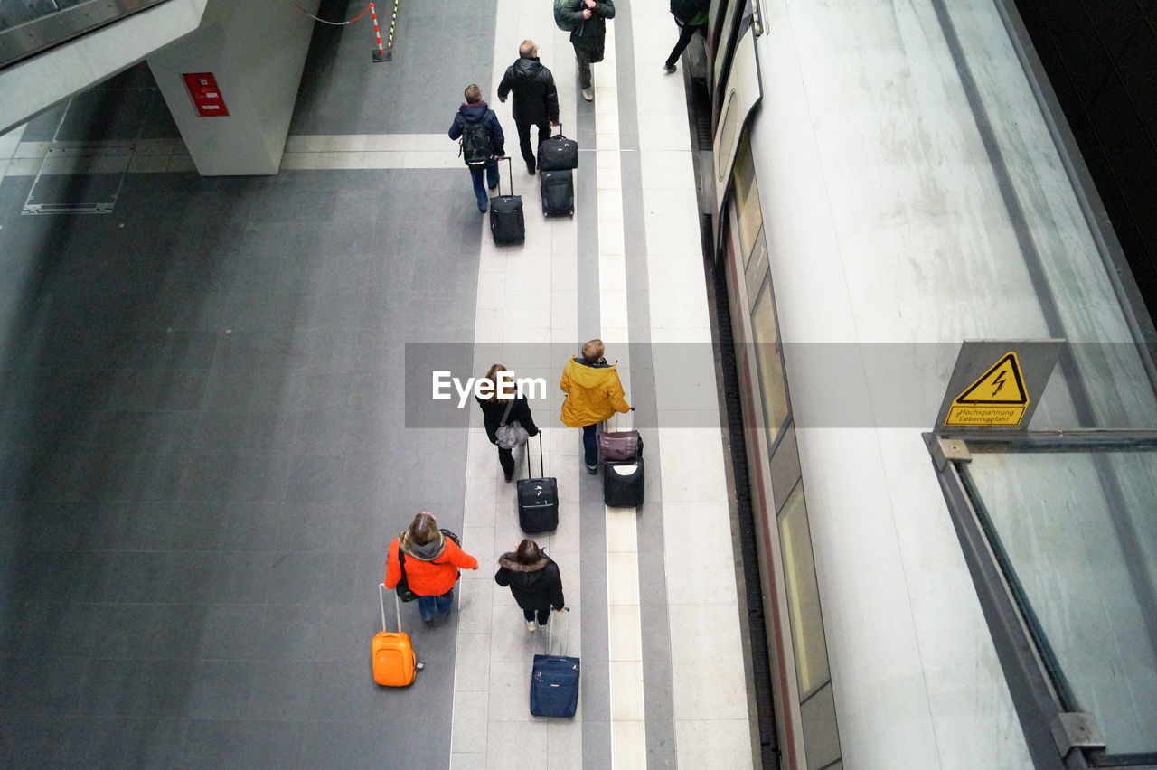 High angle view of people with luggage walking in station