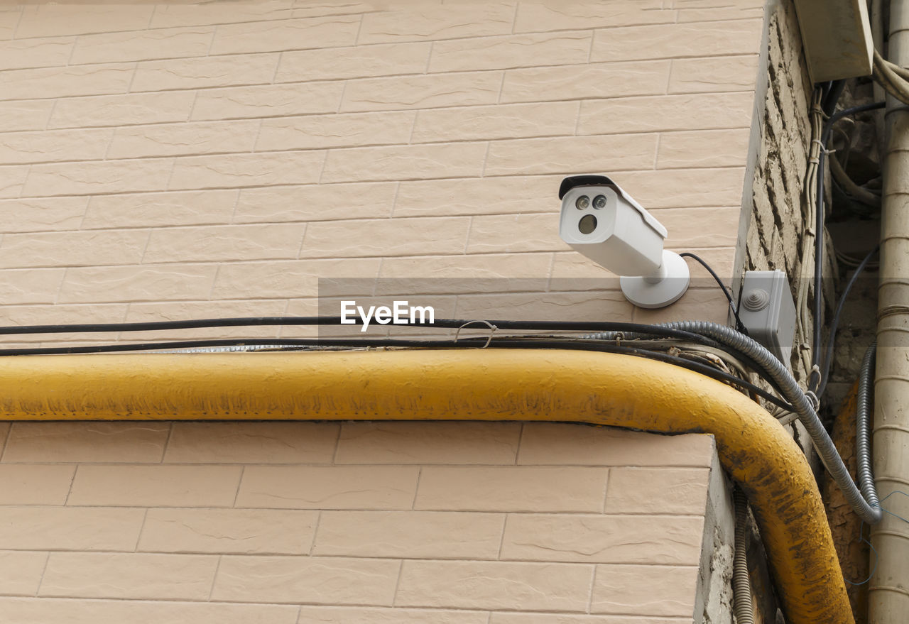 Low angle view of security camera on wall