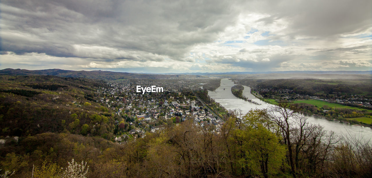 Scenic view of river flowing on landscape against cloudy sky