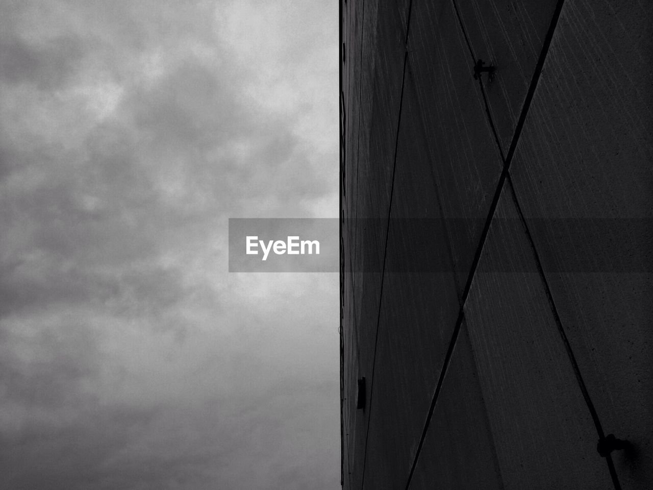 Low angle view of wall against cloudy sky