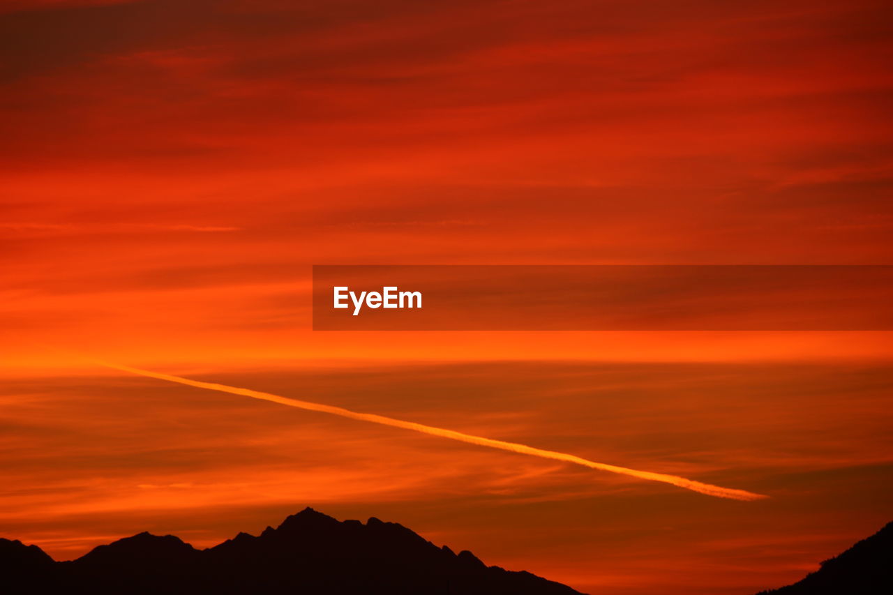 SCENIC VIEW OF DRAMATIC SKY OVER SILHOUETTE MOUNTAINS