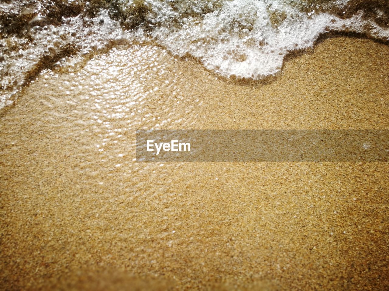 HIGH ANGLE VIEW OF WATER ON BEACH