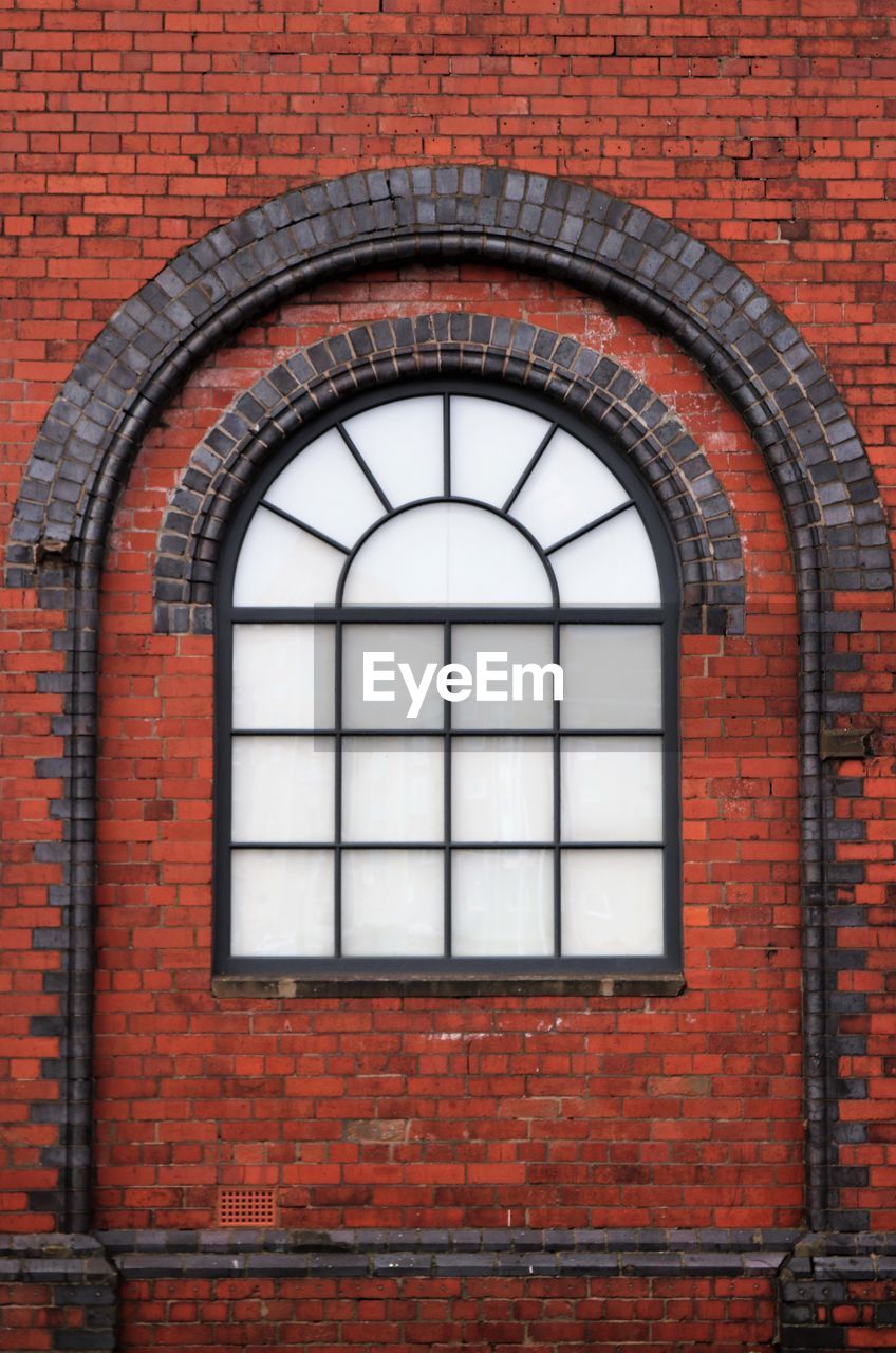 Full frame shot of arched window on brick wall