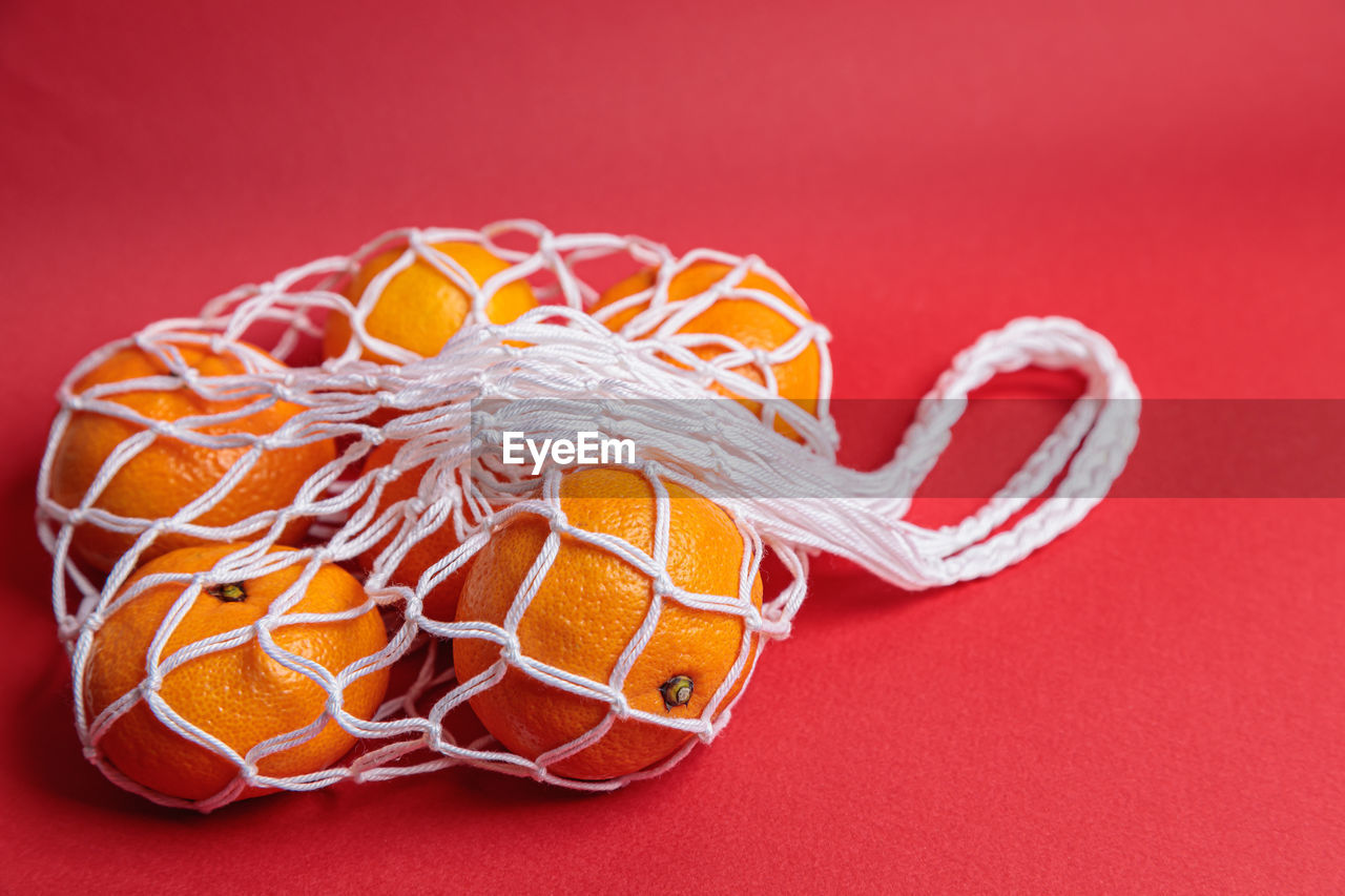 orange, colored background, studio shot, no people, red, indoors, red background, orange color, jewellery, food, food and drink, close-up, fashion accessory, still life