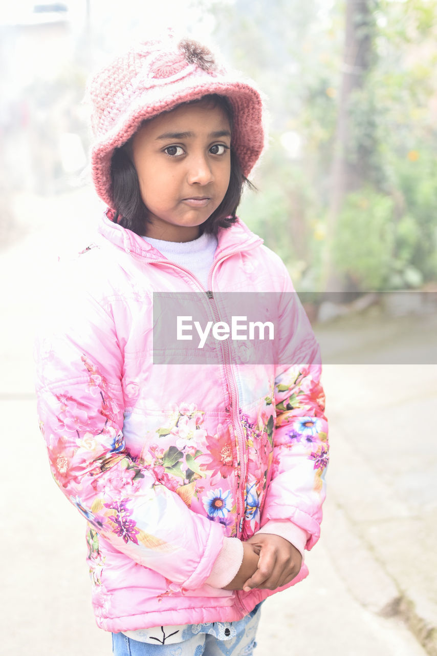 Portrait of cute girl standing on road