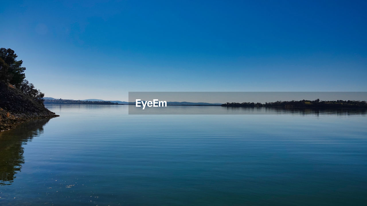 Scenic view of lake against blue sky