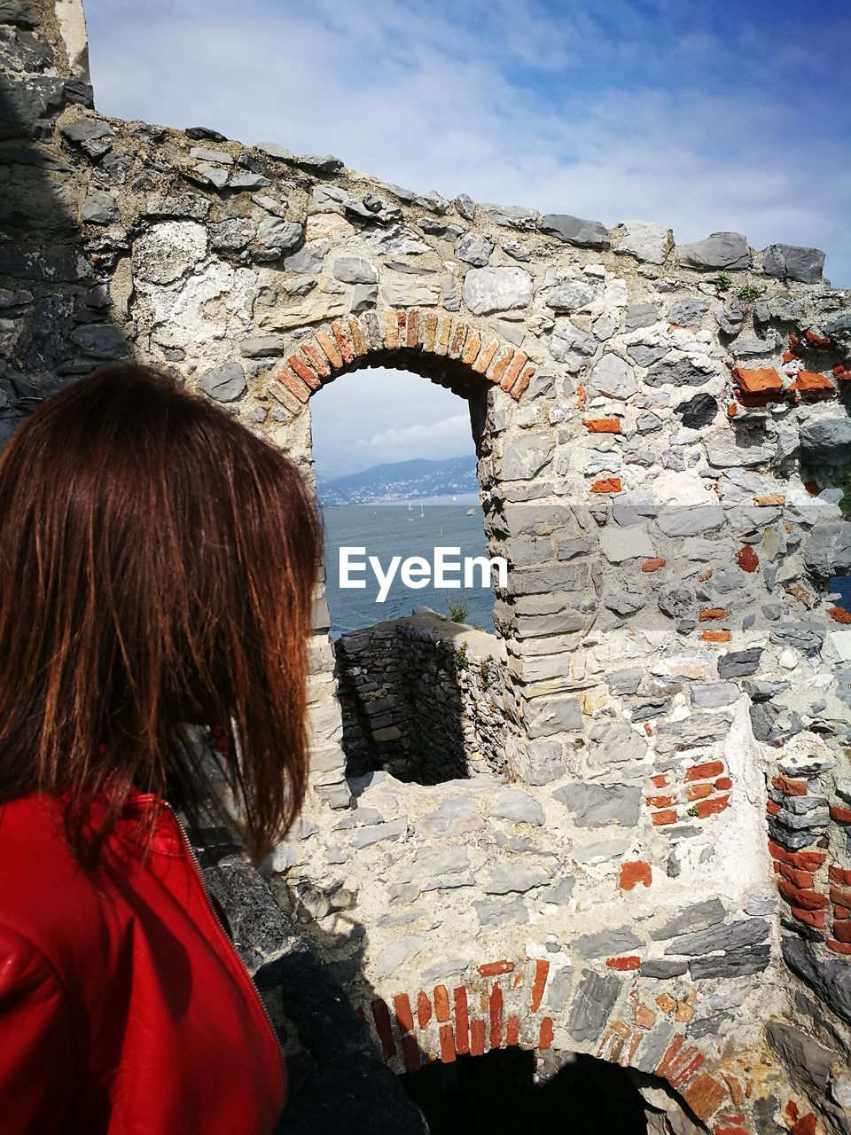 REAR VIEW OF WOMAN STANDING ON ROCK FORMATION