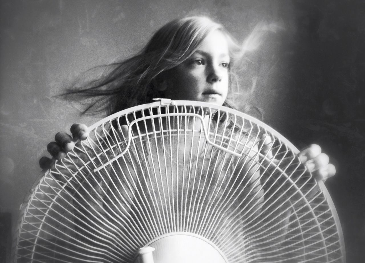 Girl in front of electric fan while looking away