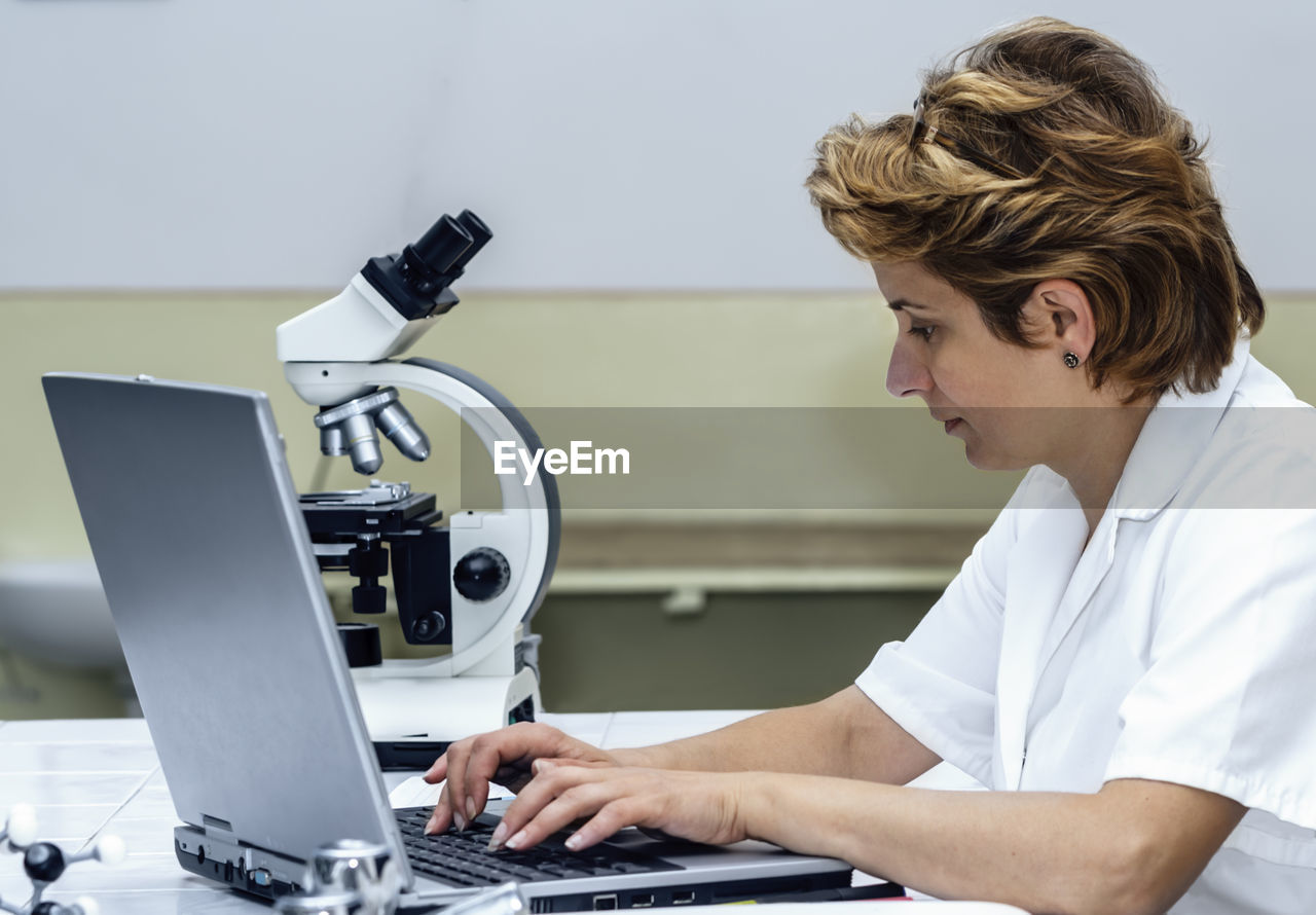 Scientist using laptop at laboratory