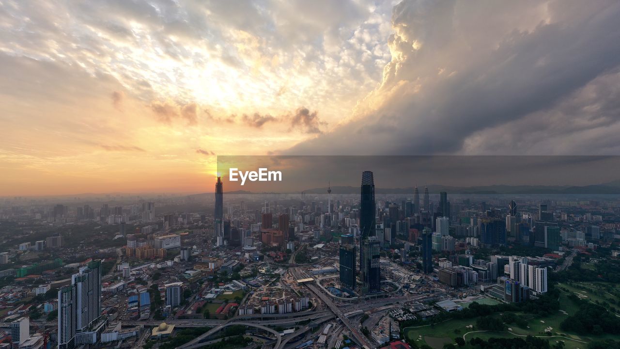 Aerial view of buildings against sky during sunset