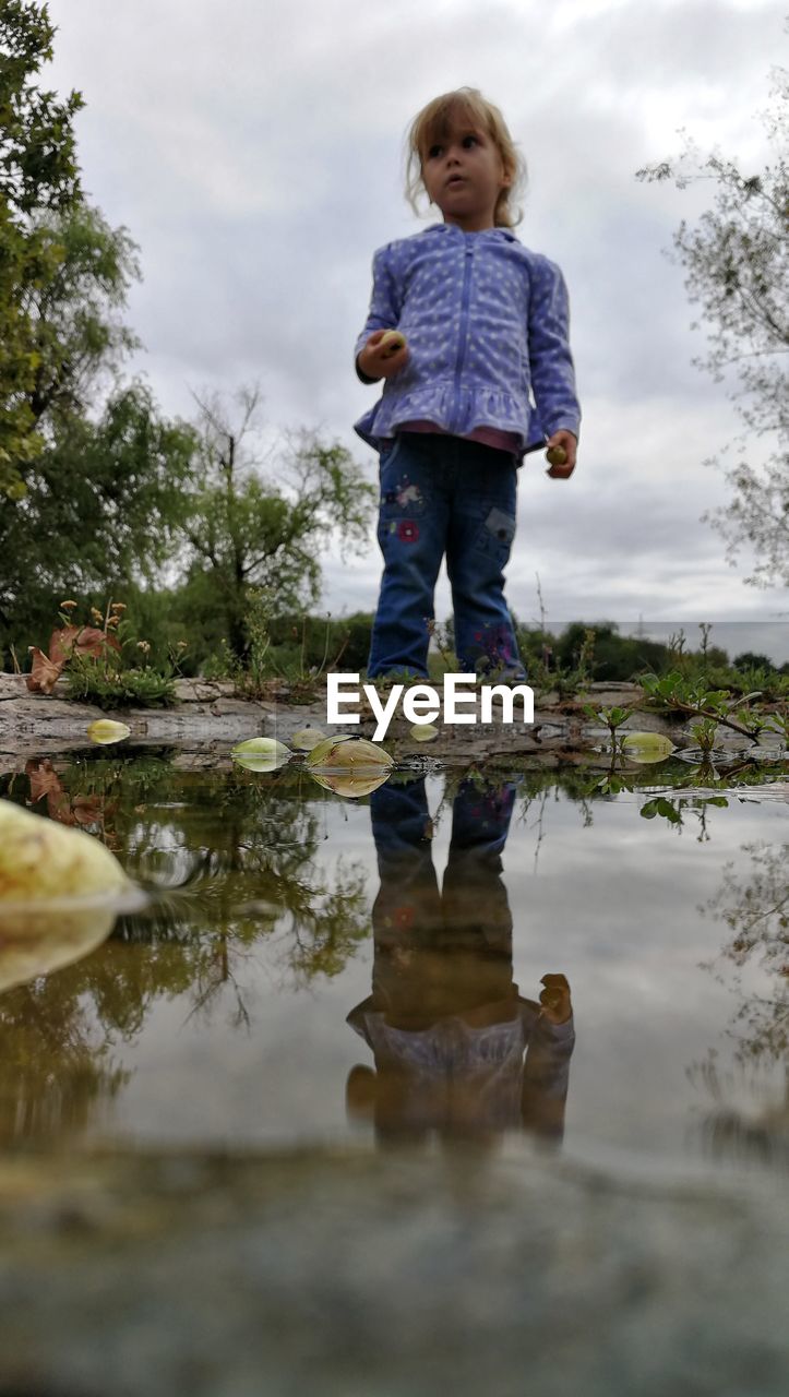 Full length of girl standing by puddle