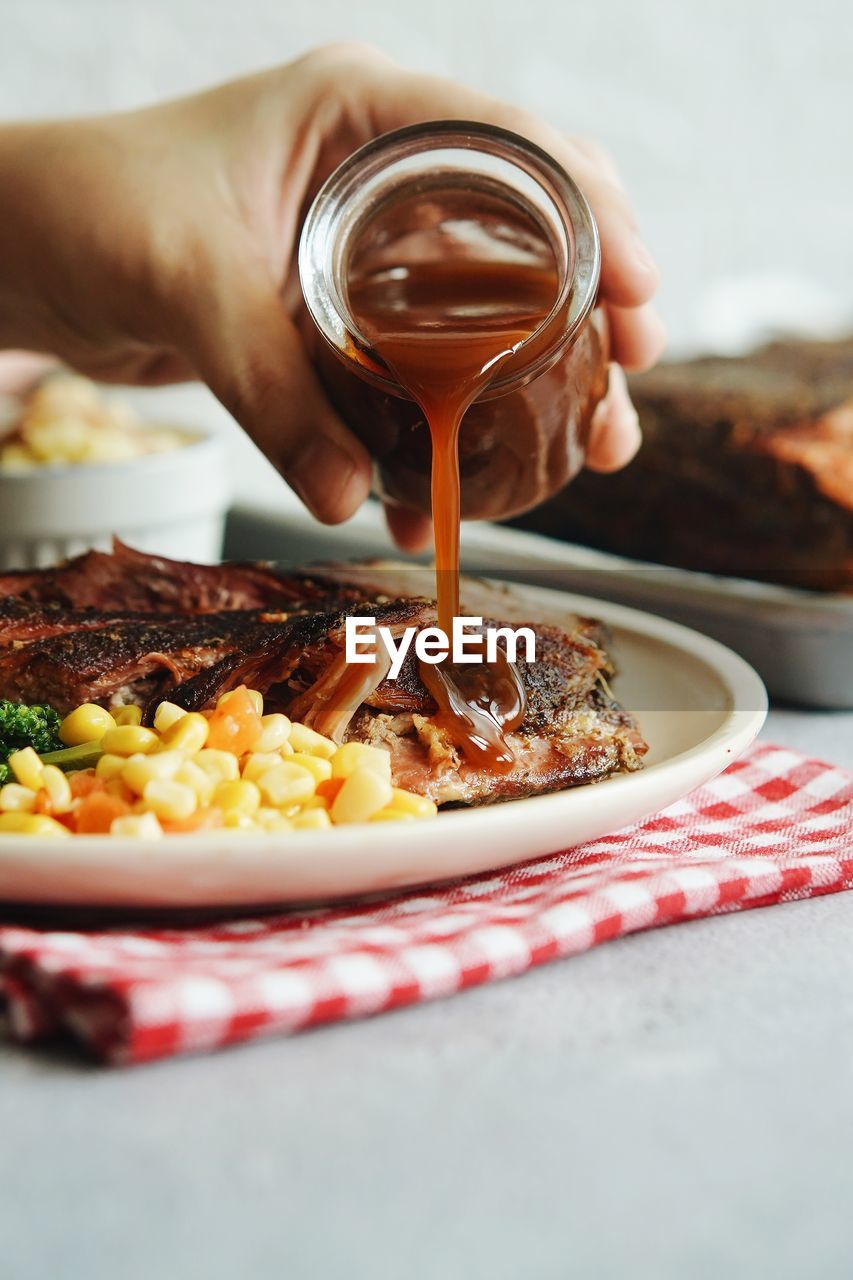 Close-up of hand holding sauce