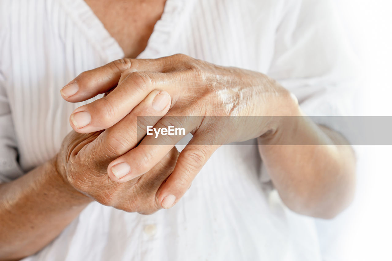 Close-up of senior woman with wrinkled fractured hands