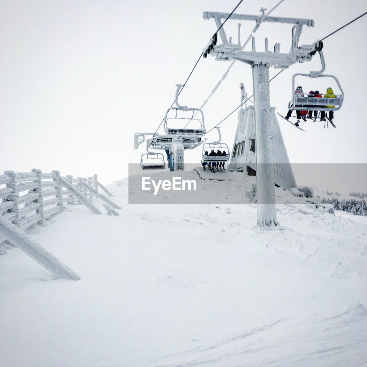 Low angle view of ski lift over snow covered mountain against sky