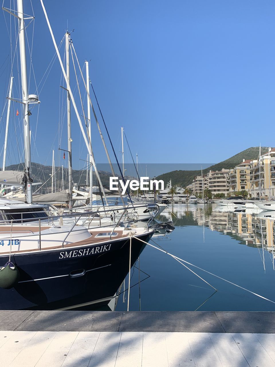 SAILBOATS MOORED IN HARBOR