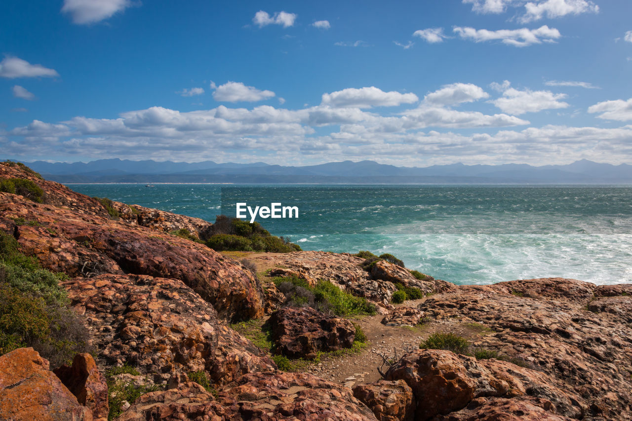 SCENIC VIEW OF ROCKS ON BEACH AGAINST SKY