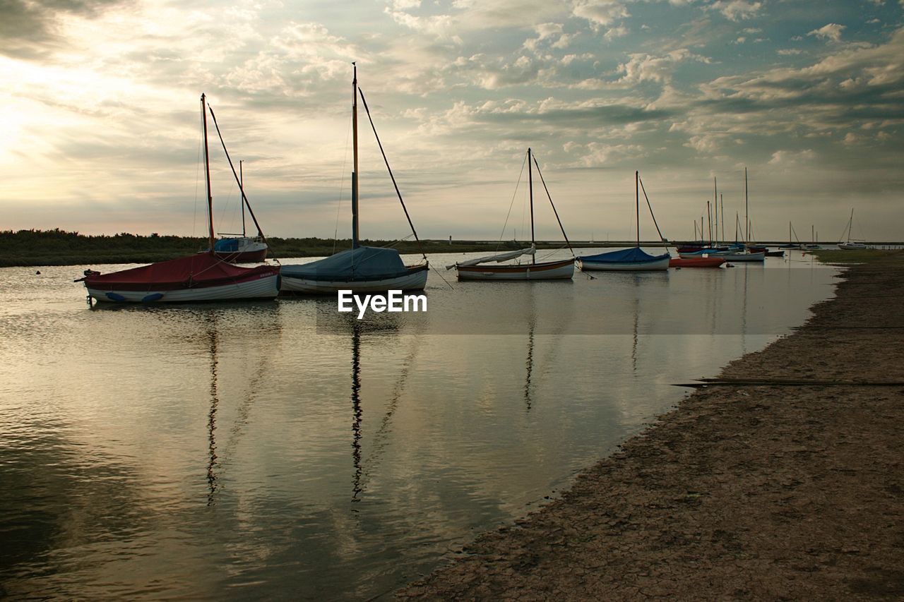 SAILBOATS MOORED IN HARBOR