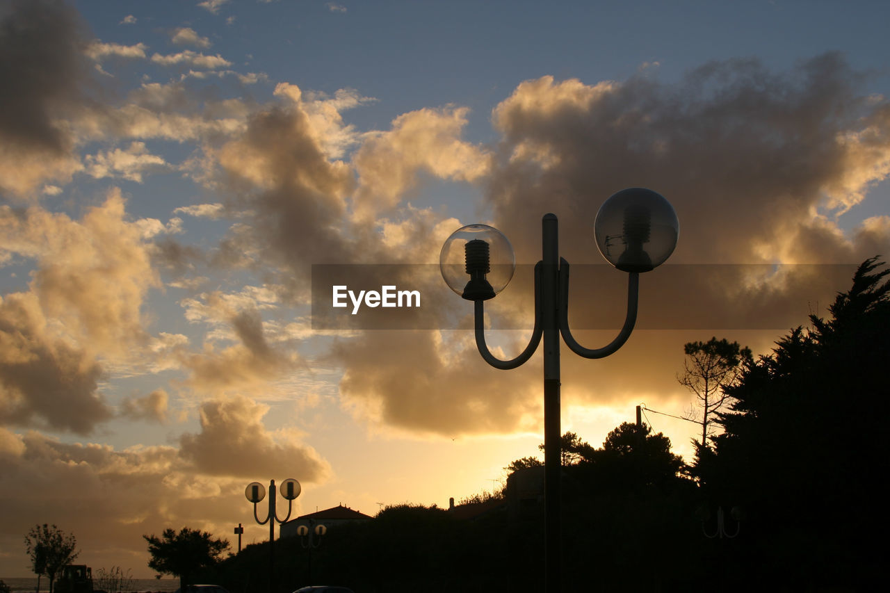 Low angle view of silhouette street light against sky