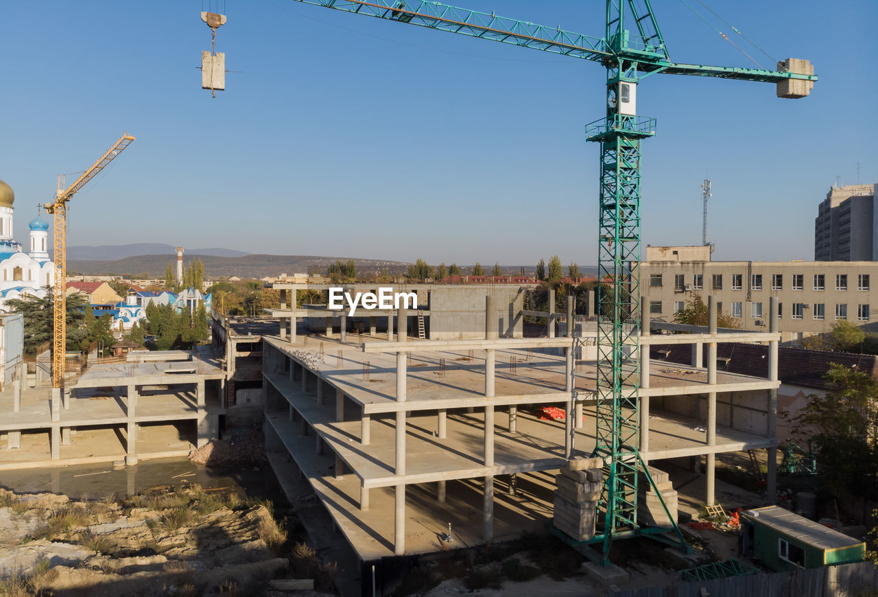 CONSTRUCTION SITE BY BUILDINGS AGAINST SKY