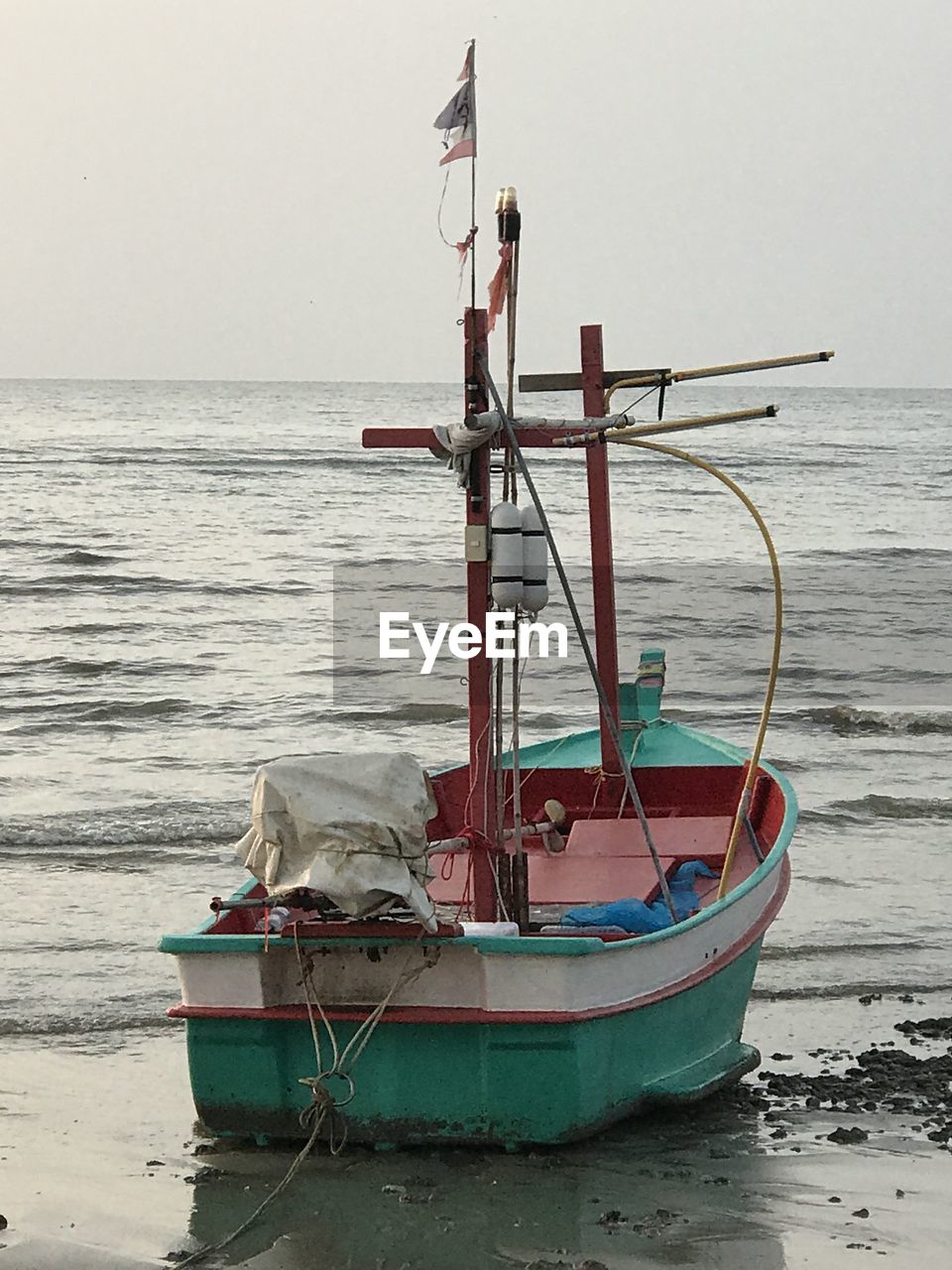 Fishing boat moored on sea against clear sky