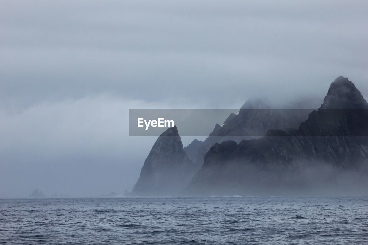 SCENIC VIEW OF SEA AND MOUNTAIN AGAINST SKY