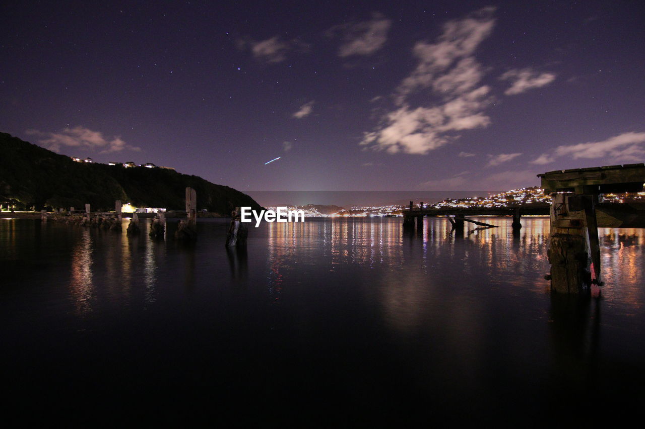 Scenic view of lake against sky at night