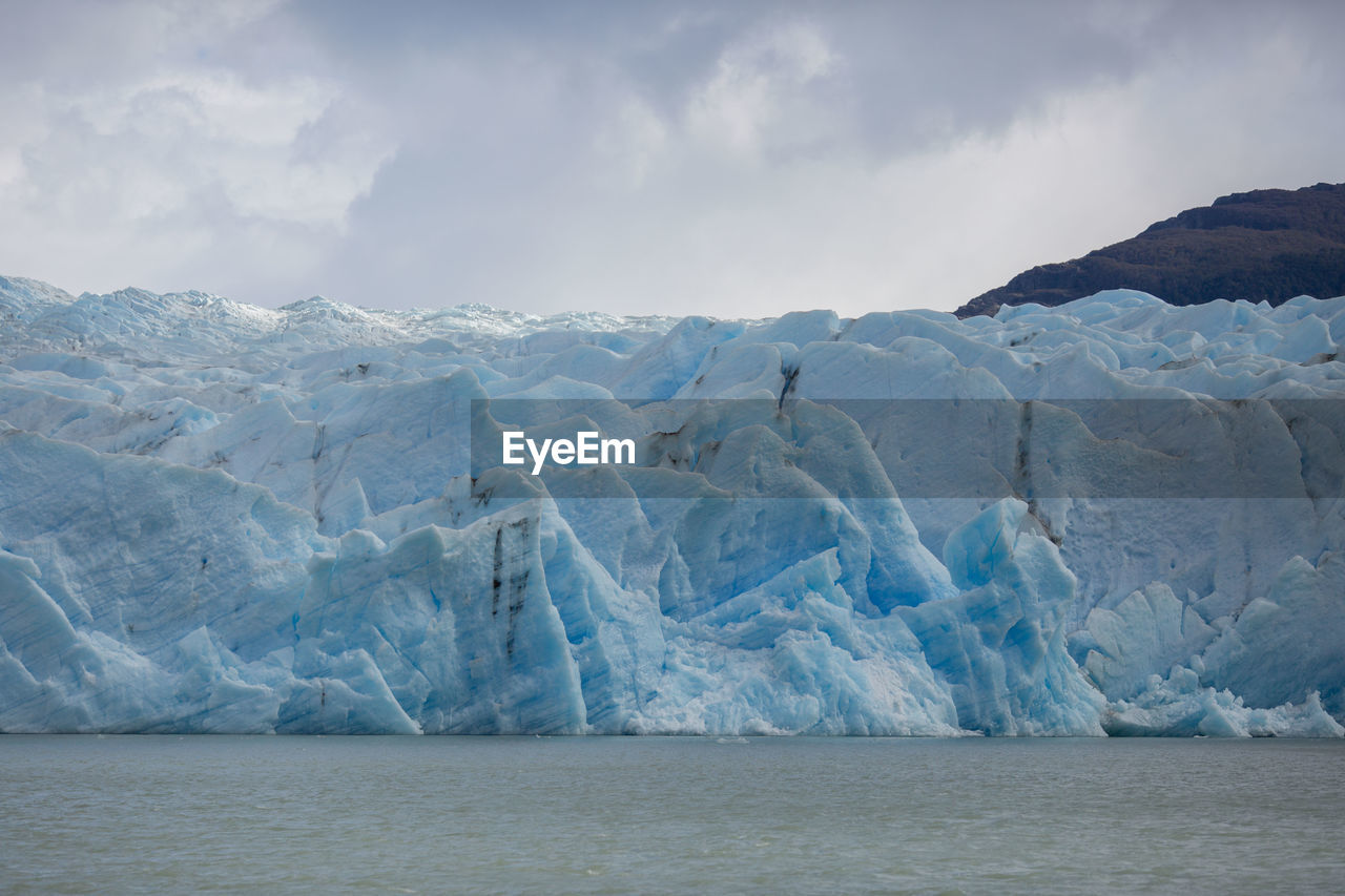 scenic view of sea and snowcapped mountains against sky