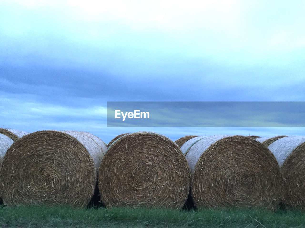 Hay bales on field against sky