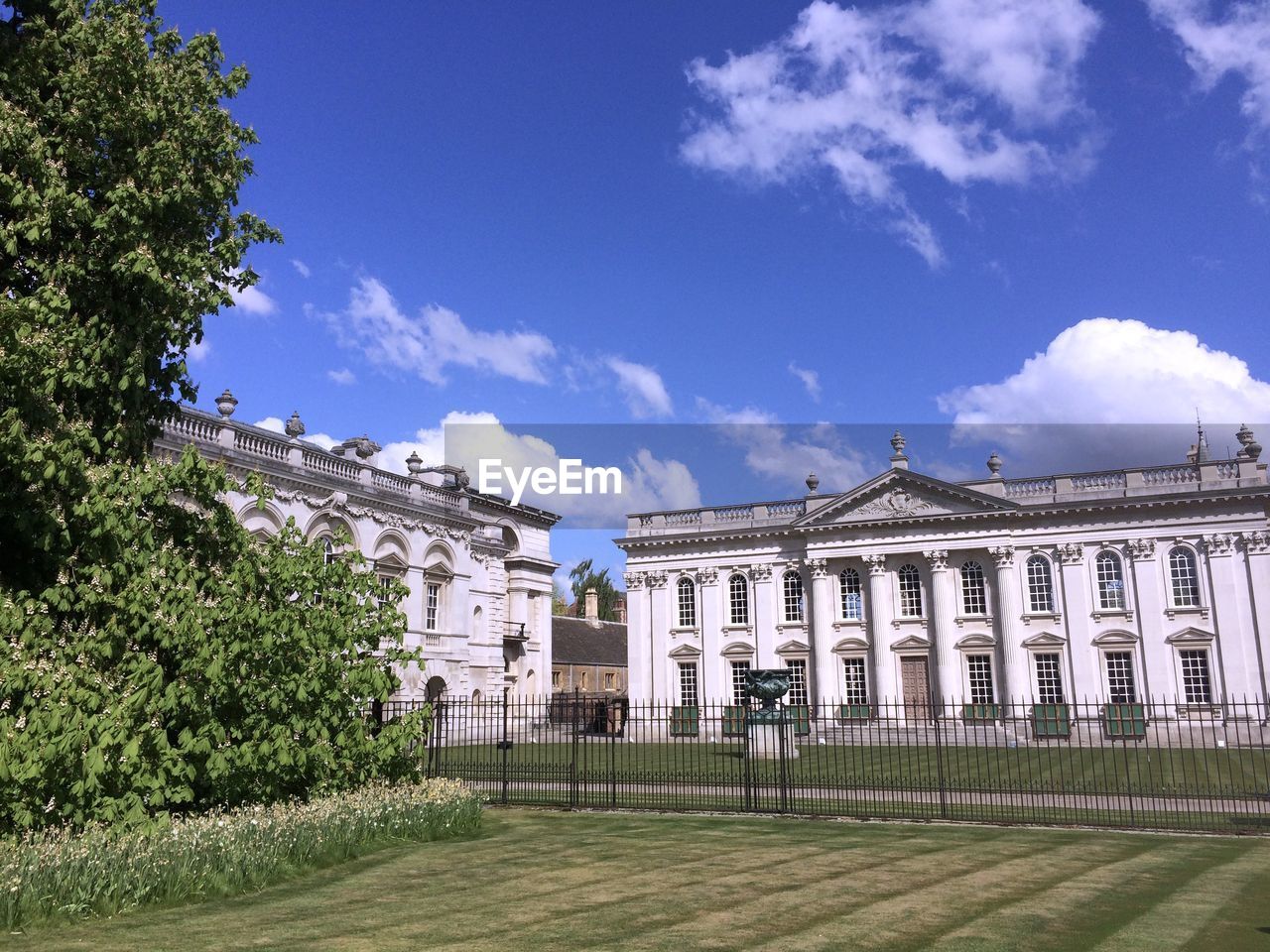 Façade of senate house and garden against blue sky