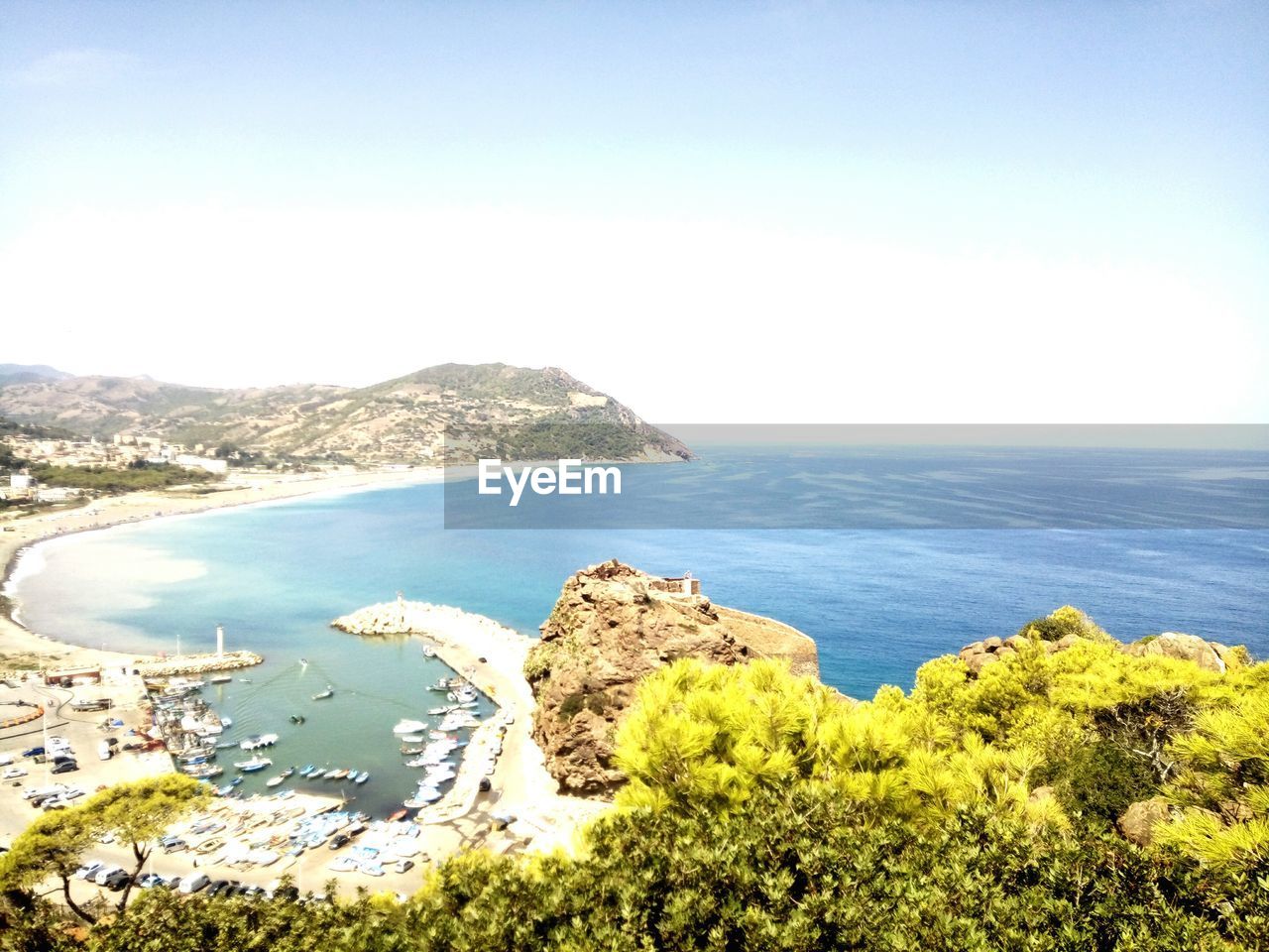 HIGH ANGLE VIEW OF SEA AND MOUNTAINS AGAINST CLEAR SKY