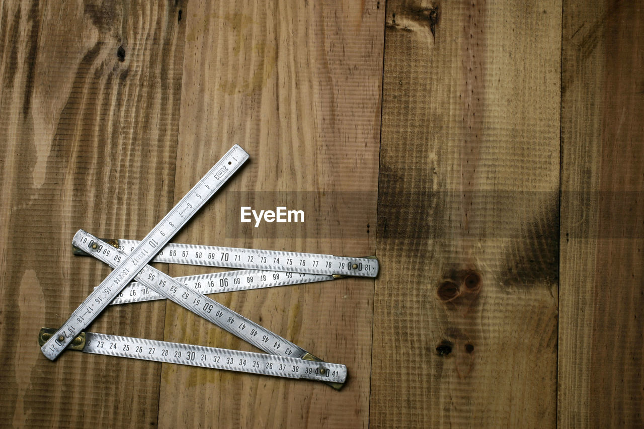 DIRECTLY ABOVE SHOT OF EQUIPMENT ON TABLE AGAINST WOODEN BACKGROUND