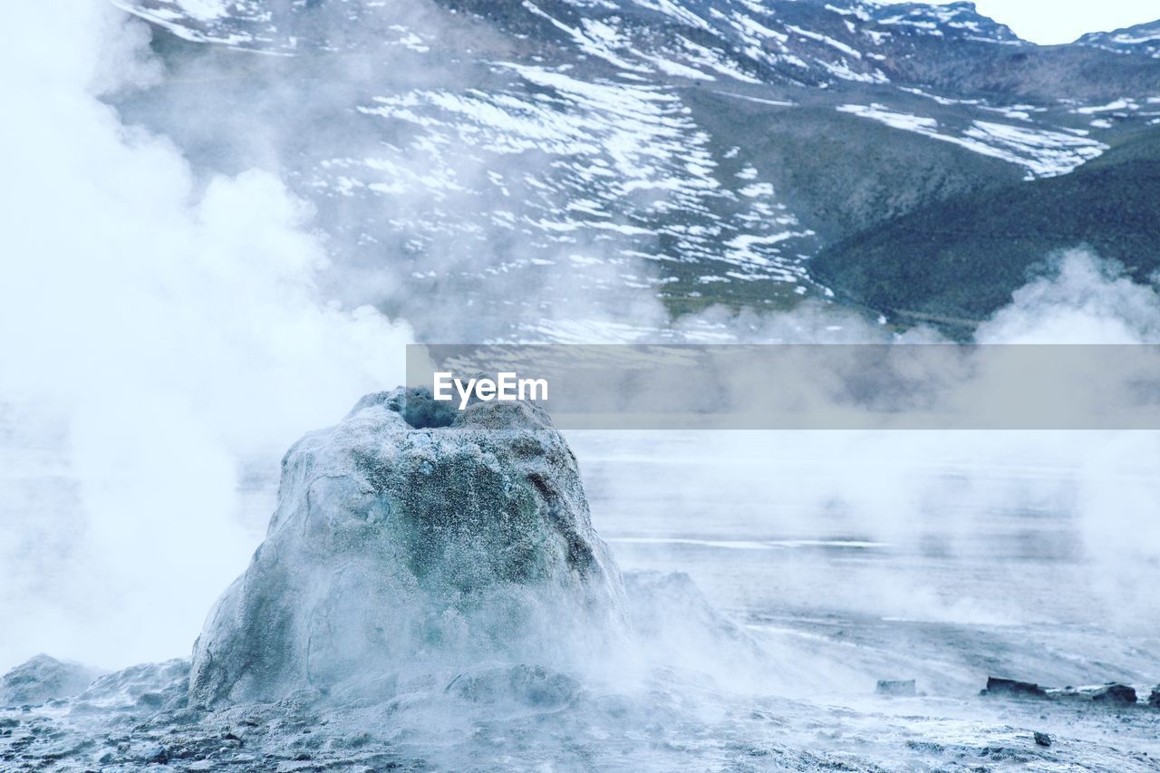 SCENIC VIEW OF WATERFALL IN MOUNTAINS