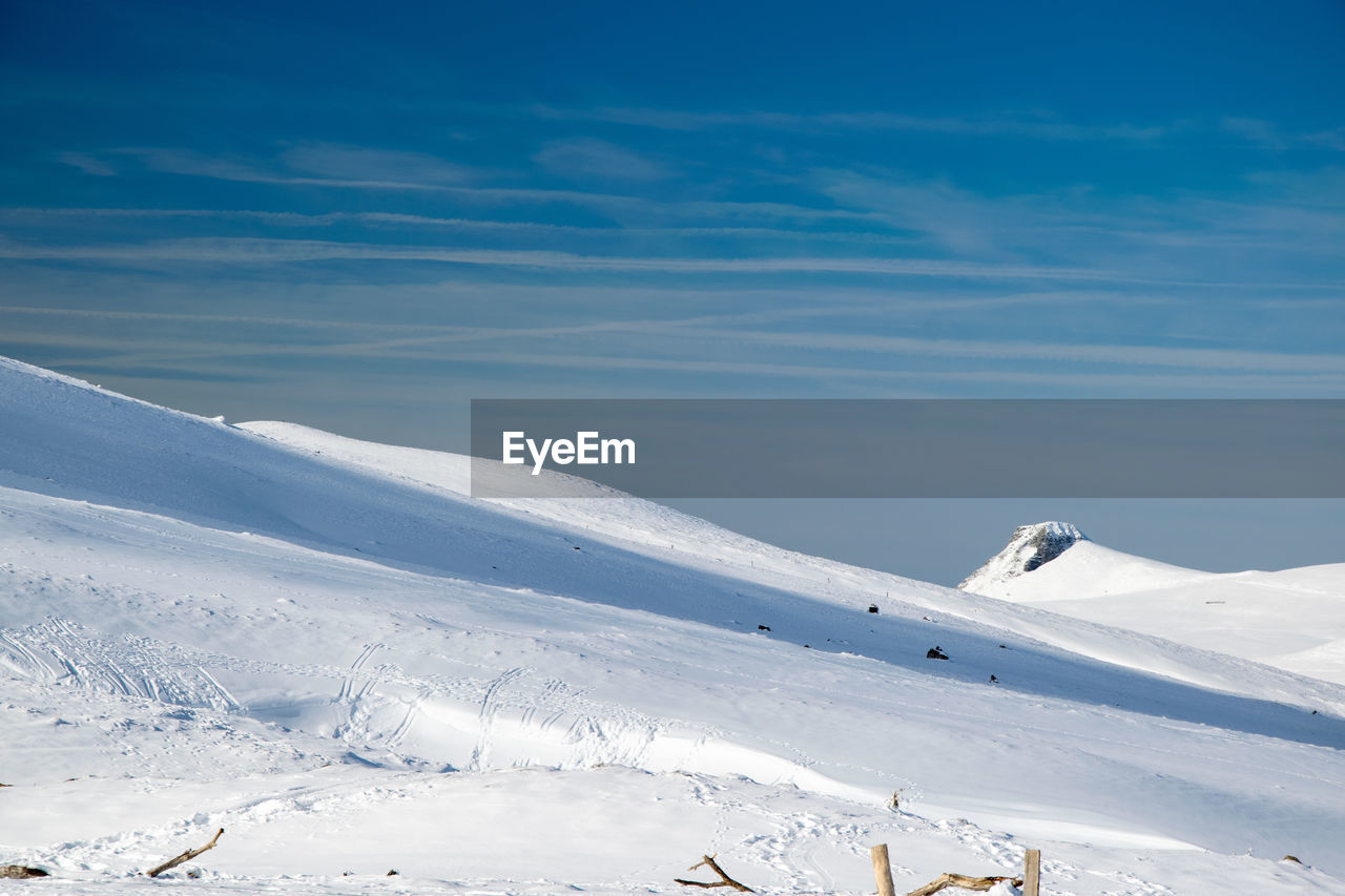Snow covered mountain against blue sky