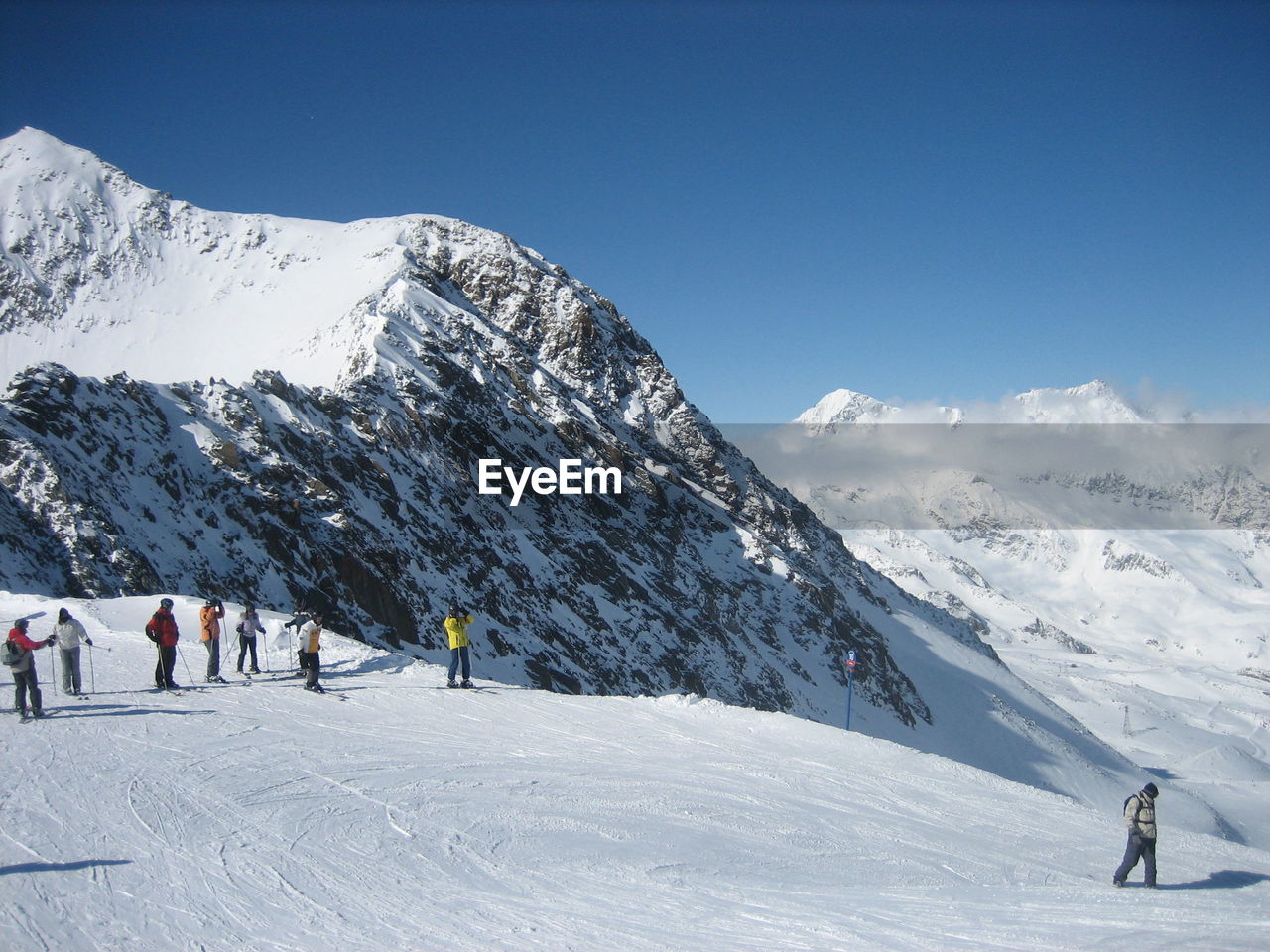 People skiing on snowcapped mountain against sky