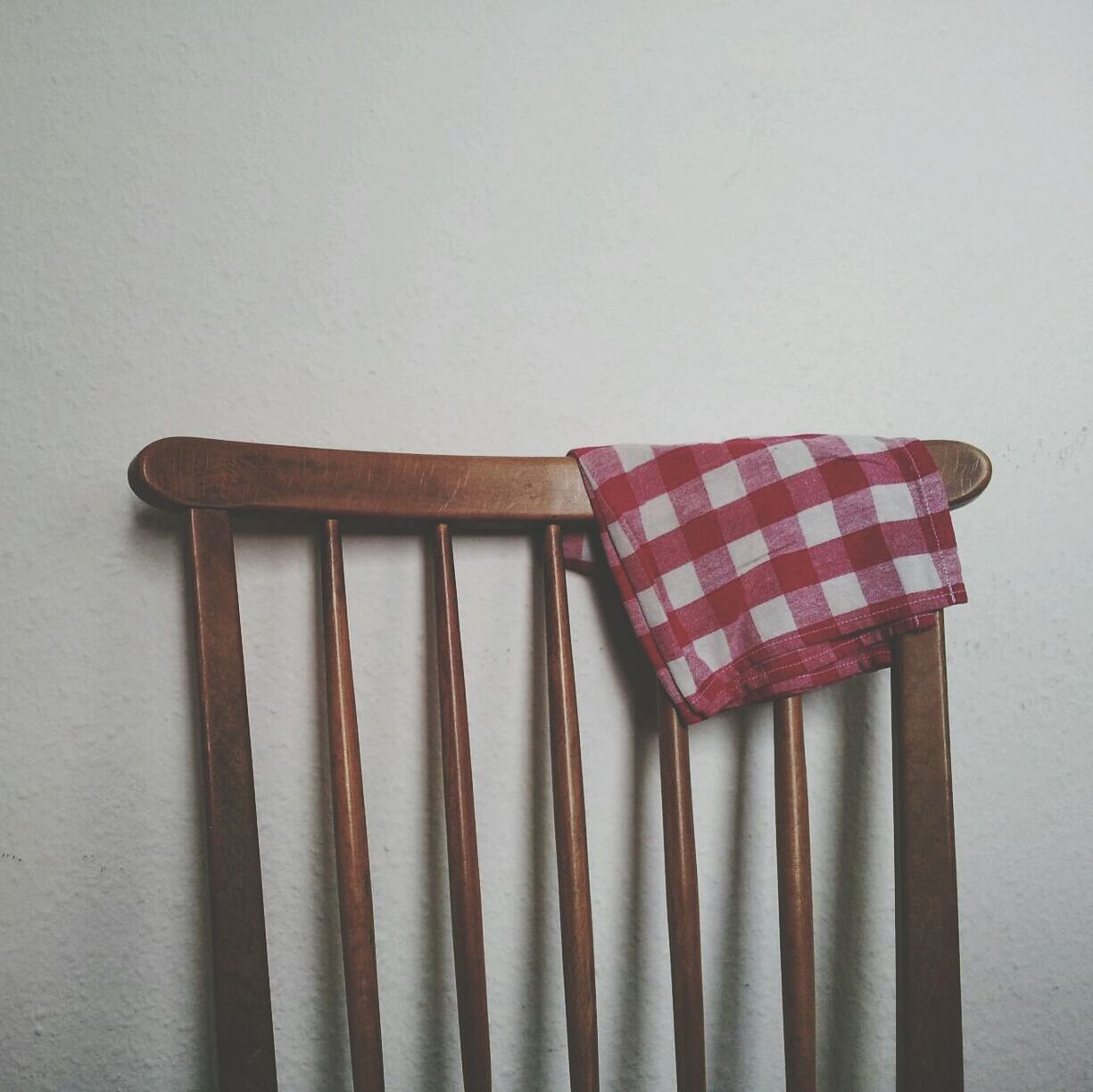 Tablecloth on wooden chair against wall in room