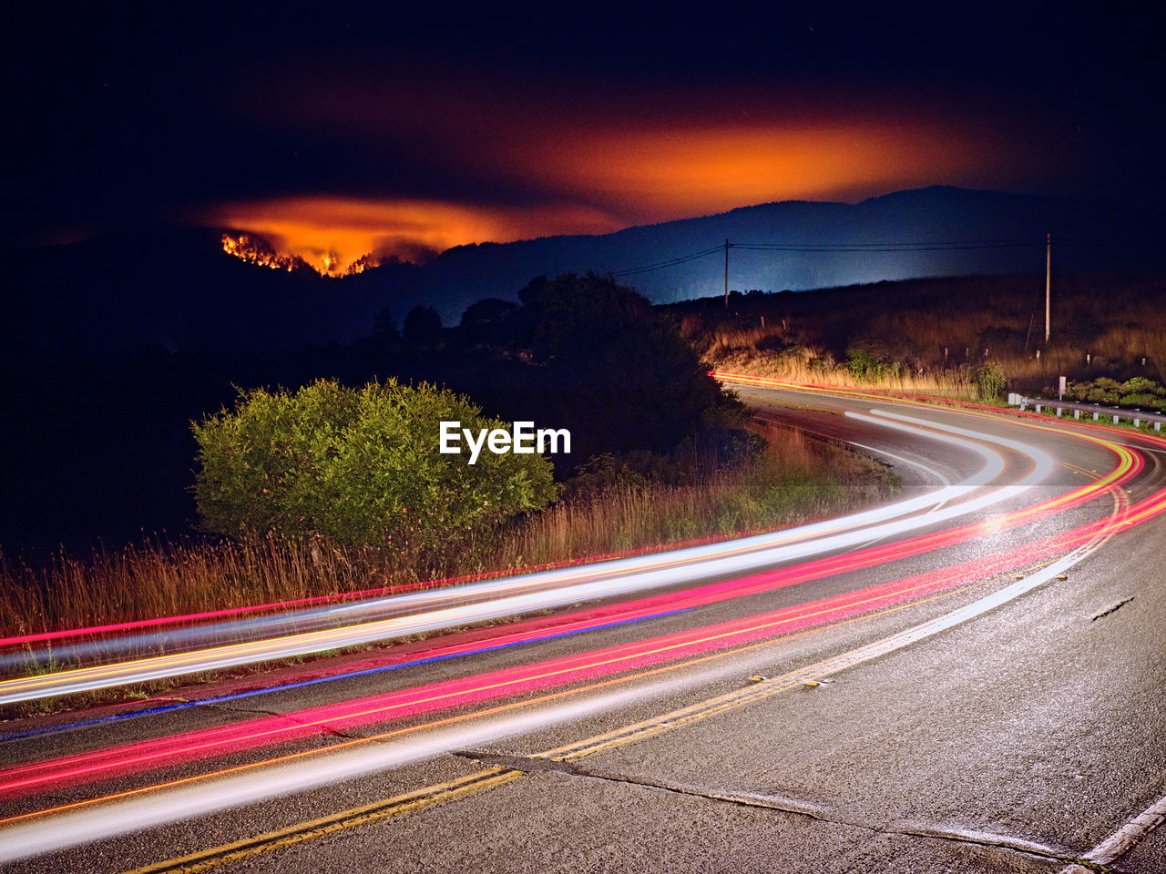 Woodward fire burning in point reyes national park, headlights on road