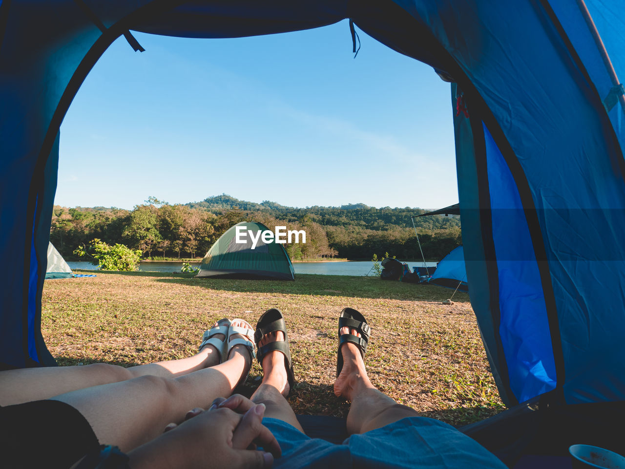 Close up of legs of couple resting in tent. happy couple inside the camping tent in the morning.