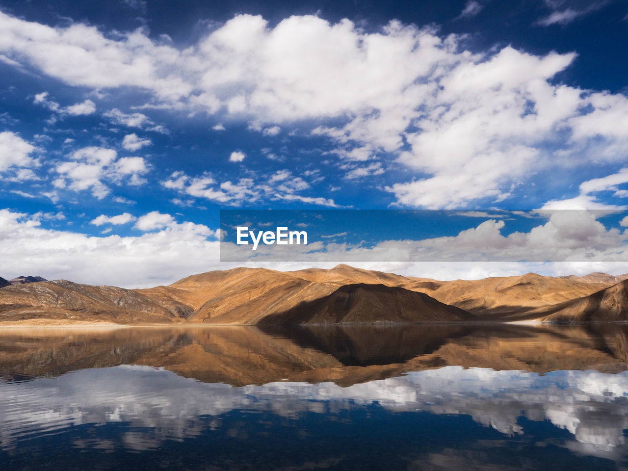 Scenic view of lake by mountains against sky