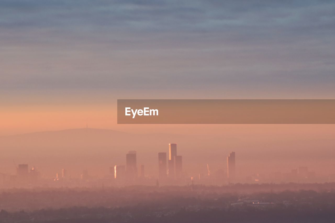 Scenic view of city skyline against sky during sunrise 
