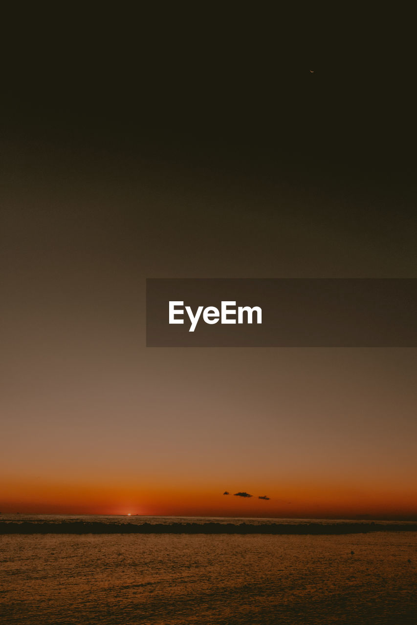 View of a beach with a sunrise in the background