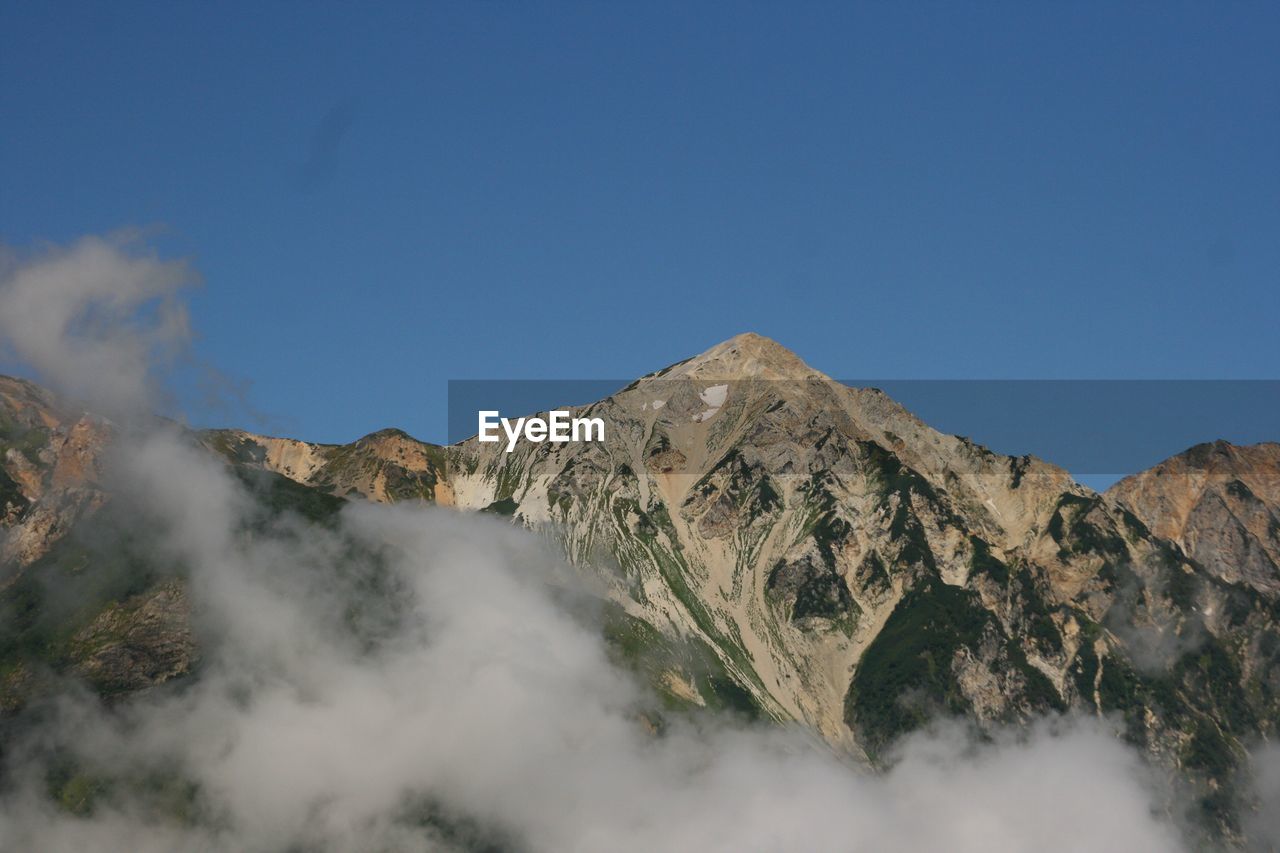 Scenic view of mountains against clear blue sky